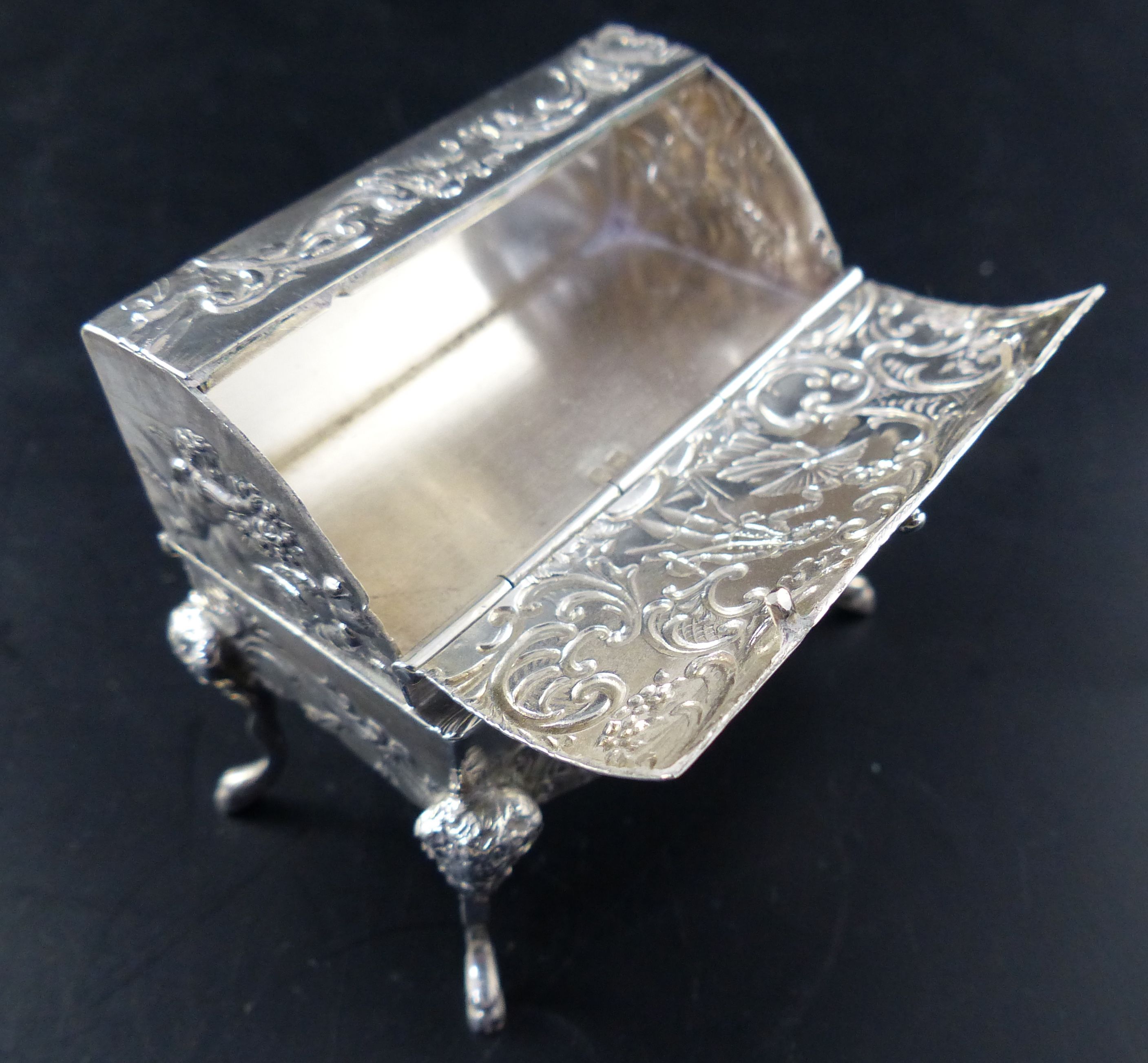 A Hanau embossed silver trinket box, formed as a miniature bureau on mask and hoof feet, width 2.5in,